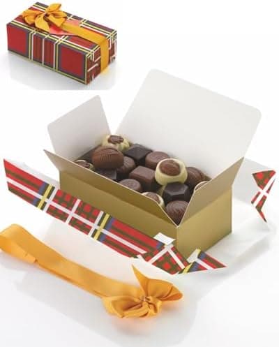 Titelbild des Pralinen-Ballotins: verstreutes Papier, Schleife und geöffnete Box